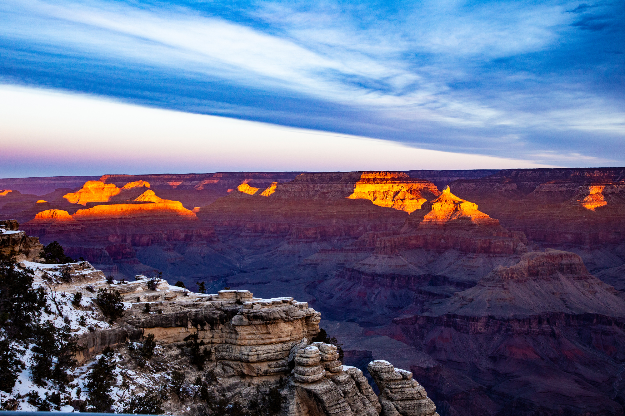 Sunrise over the Grand Canyon in winter. Golden hills, blue skies.