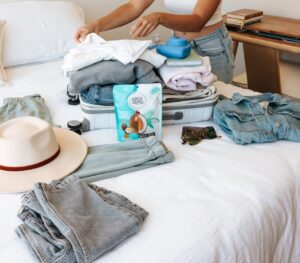 Items laid on bed for packing into a suitcase for a trip